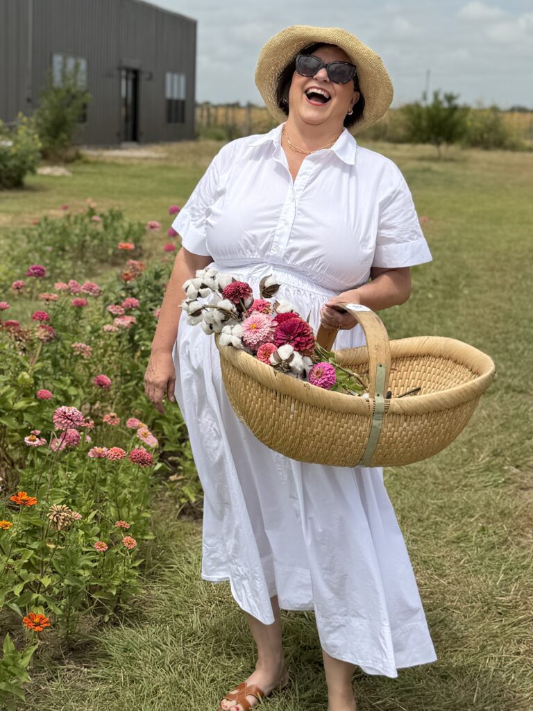 The Hill Country Bon Vivant laughing while cutting flowers enjoying her day in Fredericksburg TX
